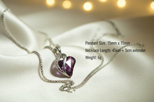 Heart-shaped purple gemstone pendant on a chain against a light green background