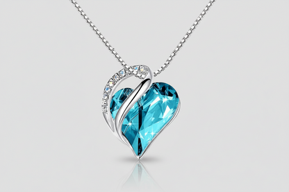 Heart-shaped blue pendant necklace on a light gray background