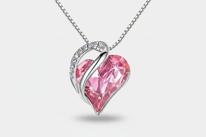 Pink heart-shaped pendant with silver frame on a white background