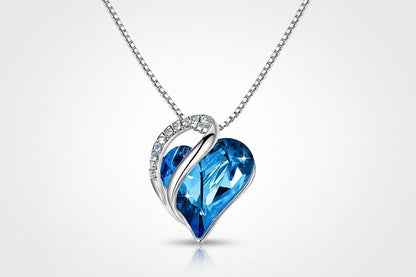 Heart-shaped blue crystal pendant on a silver chain against a white background